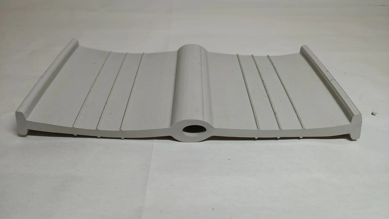 Grey PVC water stop profile showing the centre bulb between ribbed flanges