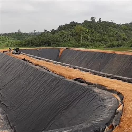 Black PVC geomembrane lining the slopes and floor of a large containment basin